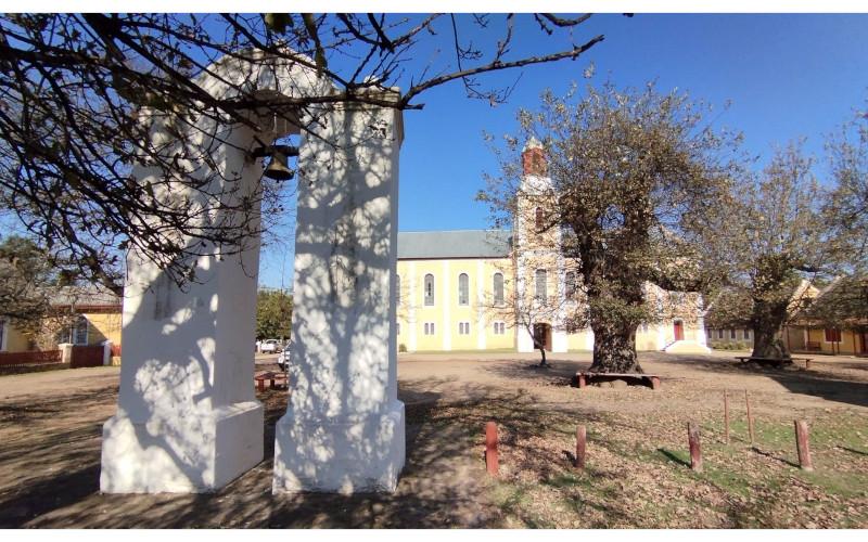 The church of the Moravian community with the historical bell in the foreground | Photograph © Jürgen May